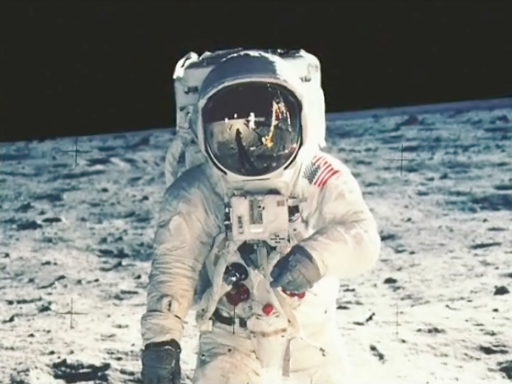 Ein Astronaut auf der Mondoberfläche, reflektiert die Erde und andere Astronauten im Visier seines Helms.