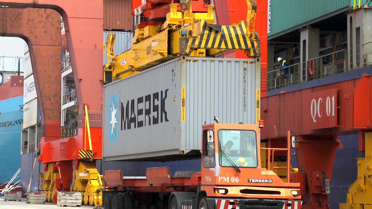 Ein Kran hebt einen Maersk-Container von einem Schiff im Hafen.