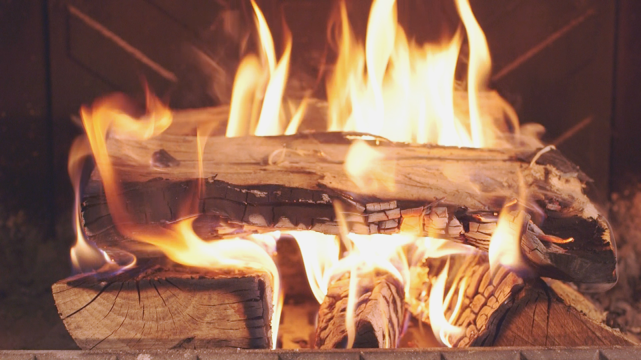 Loderndes Feuer in einem Kamin mit brennenden Holzscheiten.