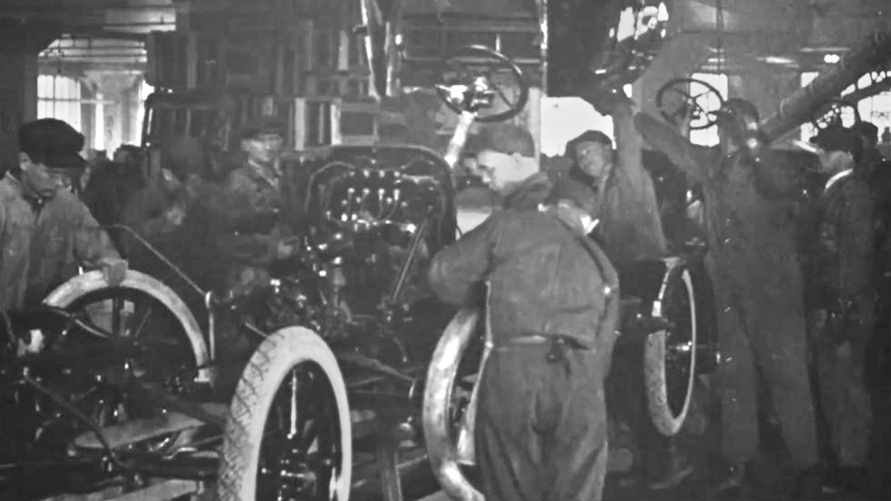 Arbeiter in einer Autofabrik montieren Fahrzeuge in einer Produktionslinie.