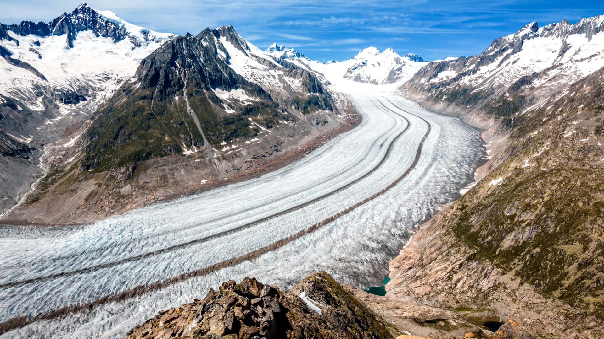 Landschaft mit einem großen Gletscher, der sich zwischen schroffen Bergen ins Tal windet