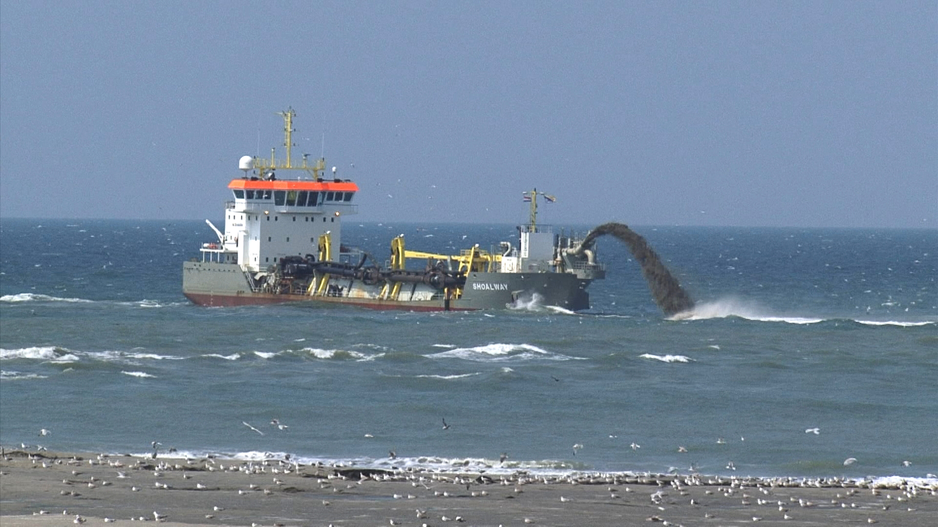 Baggerschiff entnimmt Sediment vom Meeresboden und wirft es seitlich ins Wasser