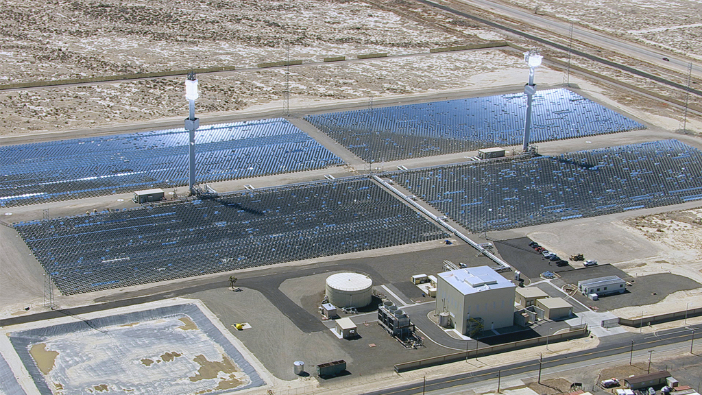 Solarkraftwerk mit reflektierenden Solarpanelen und zwei hohen Türmen, die Sonnenlicht konzentrieren.