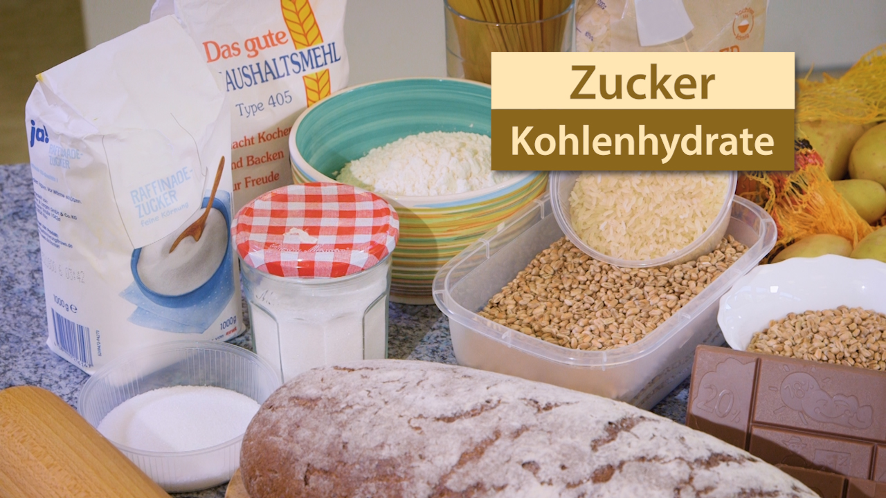 Zutaten für das Backen: Mehl, Zucker, Haferflocken, Schokolade, Joghurt und Brot auf einer Arbeitsfläche.