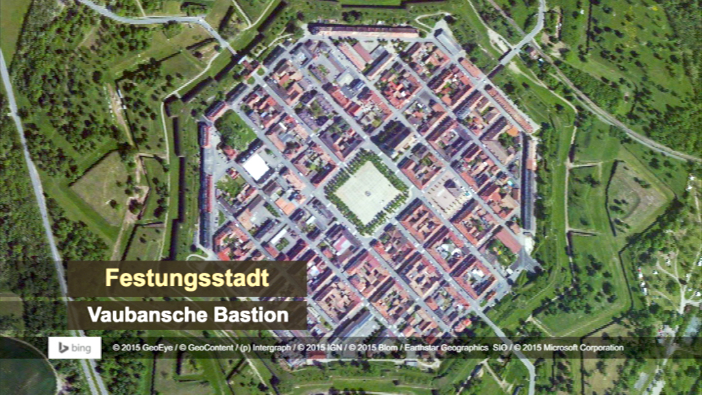 Luftaufnahme der Festungsstadt mit dem Vaubanschen Bastion, umgeben von grünen Wällen und einem klaren Stadtplan.