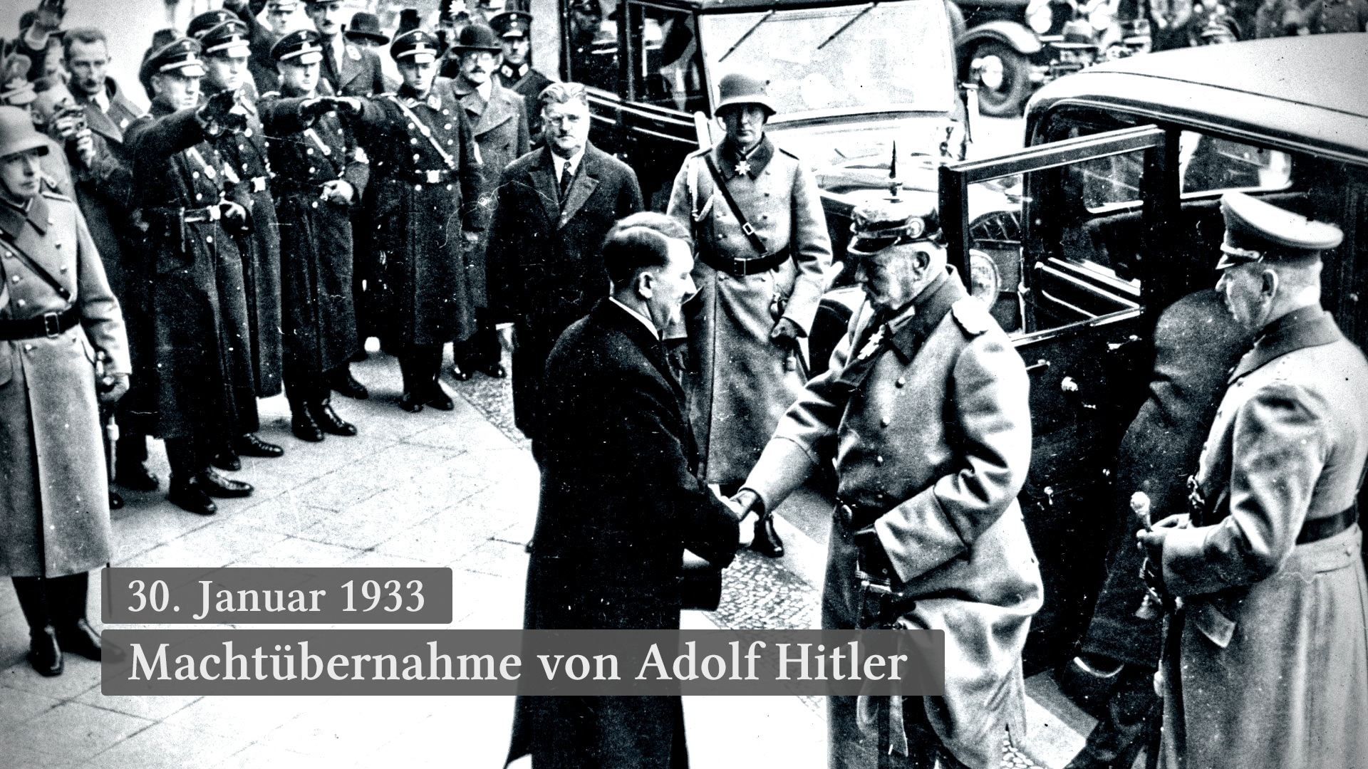 Historisches Ereignis: Adolf Hitler schüttelt einem Offizier die Hand, umgeben von Soldaten und Beamten, am 30. Januar 1933.