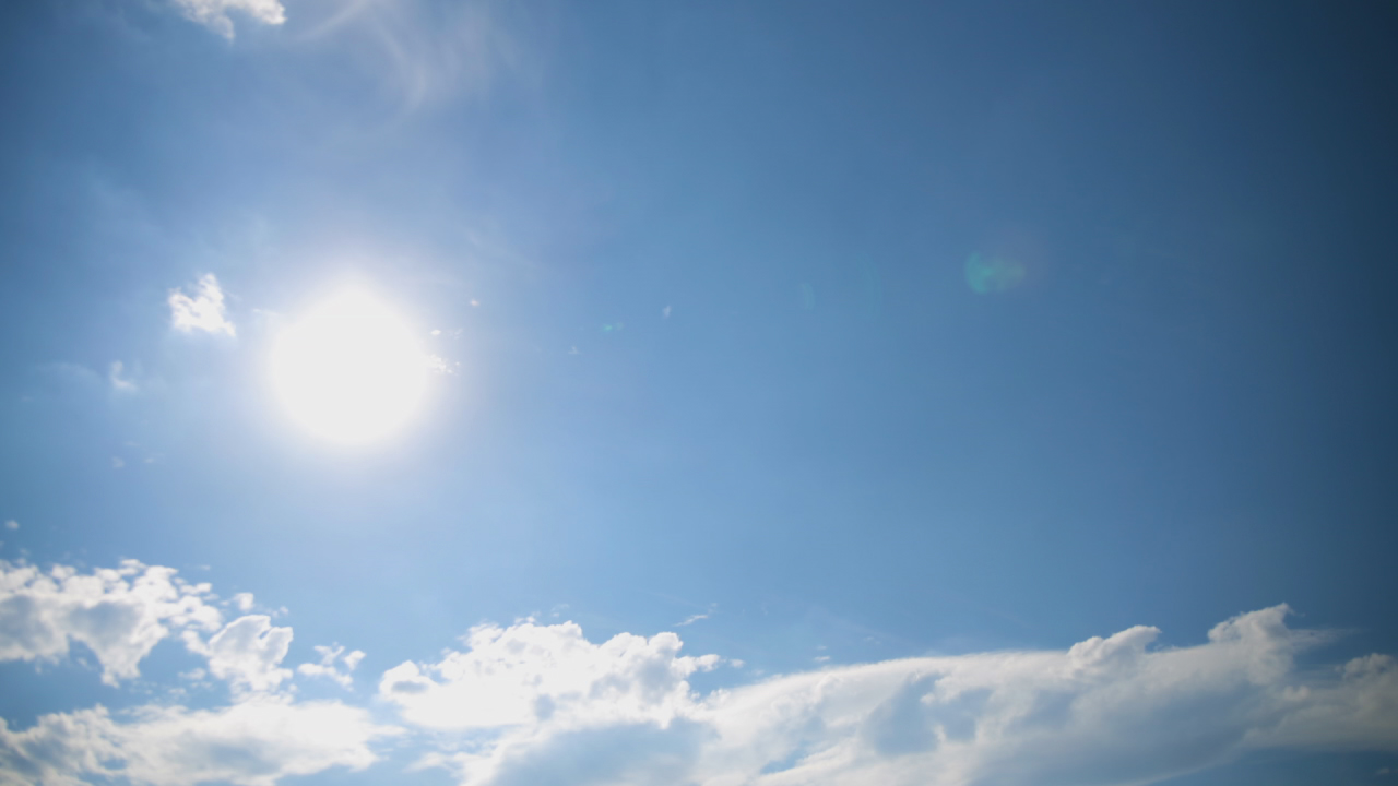 Heller Himmel mit Sonne und einigen Wolken.