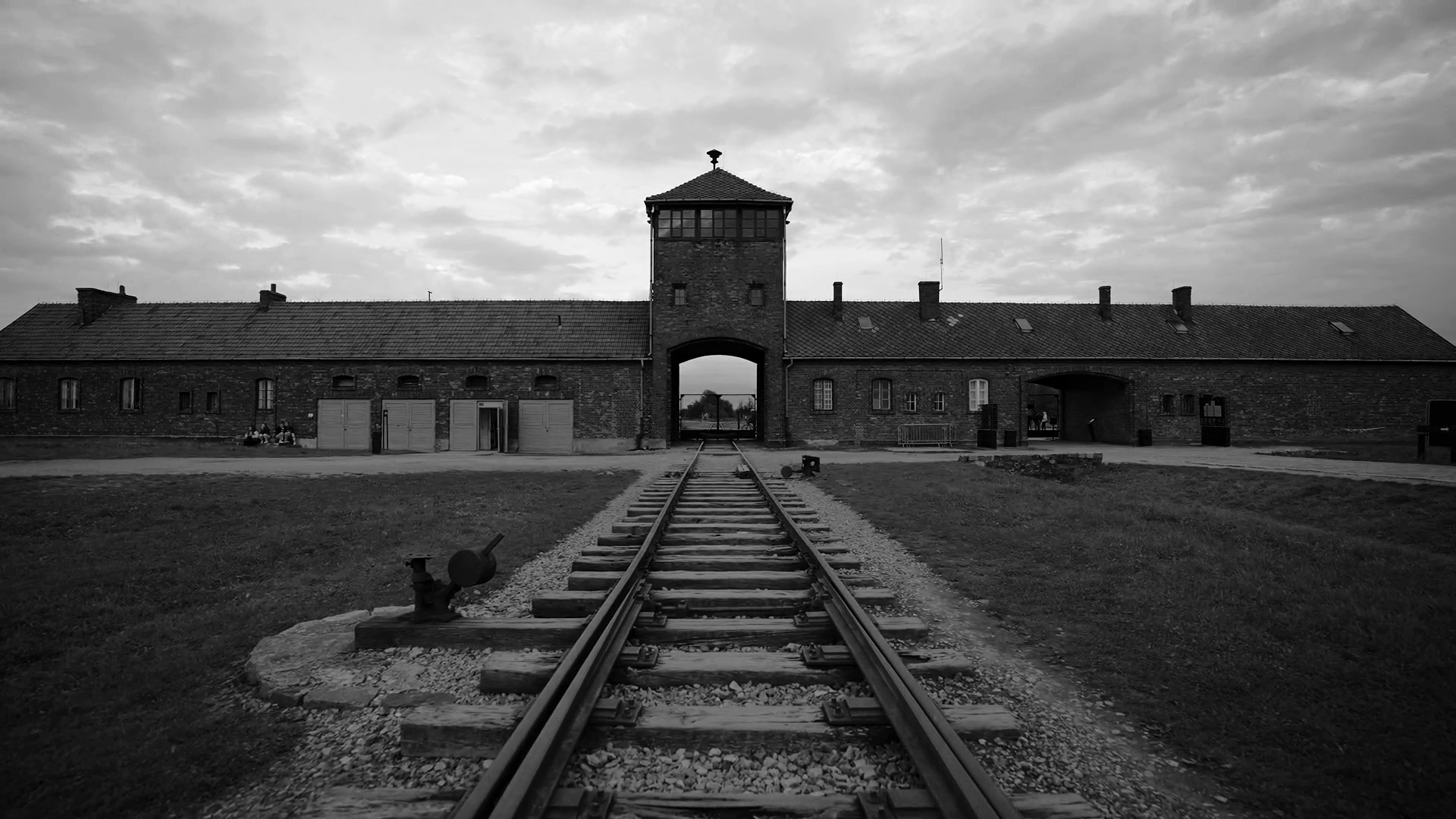 Eingang zum Konzentrationslager Auschwitz mit Schienen, die dorthin führen.