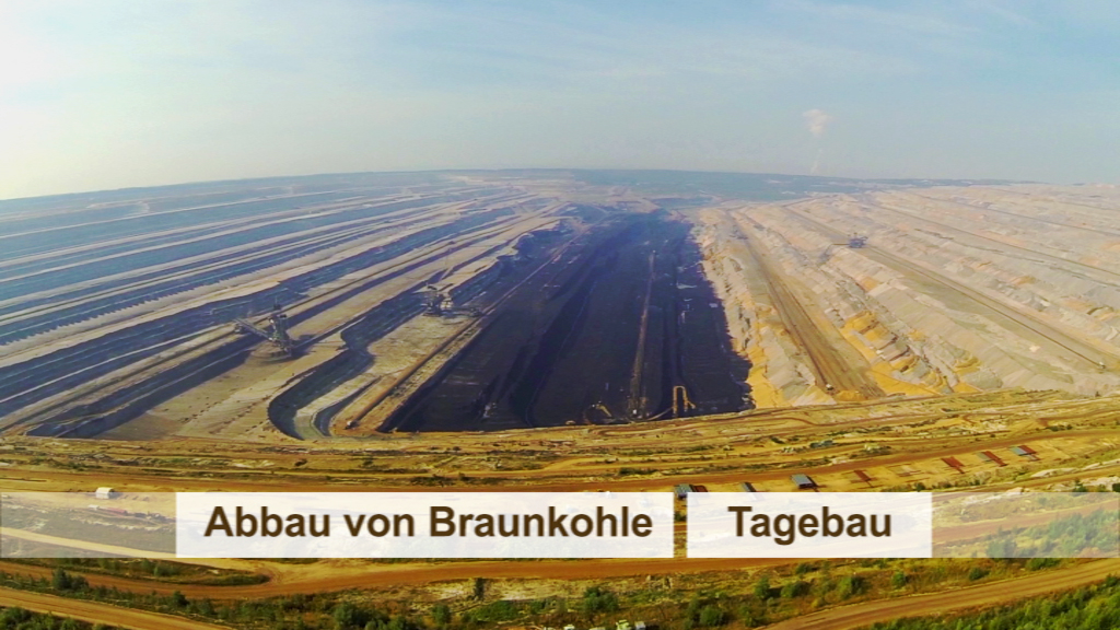 Luftaufnahme eines Tagebaus für Braunkohle mit abgebauten Flächen und Maschinen.