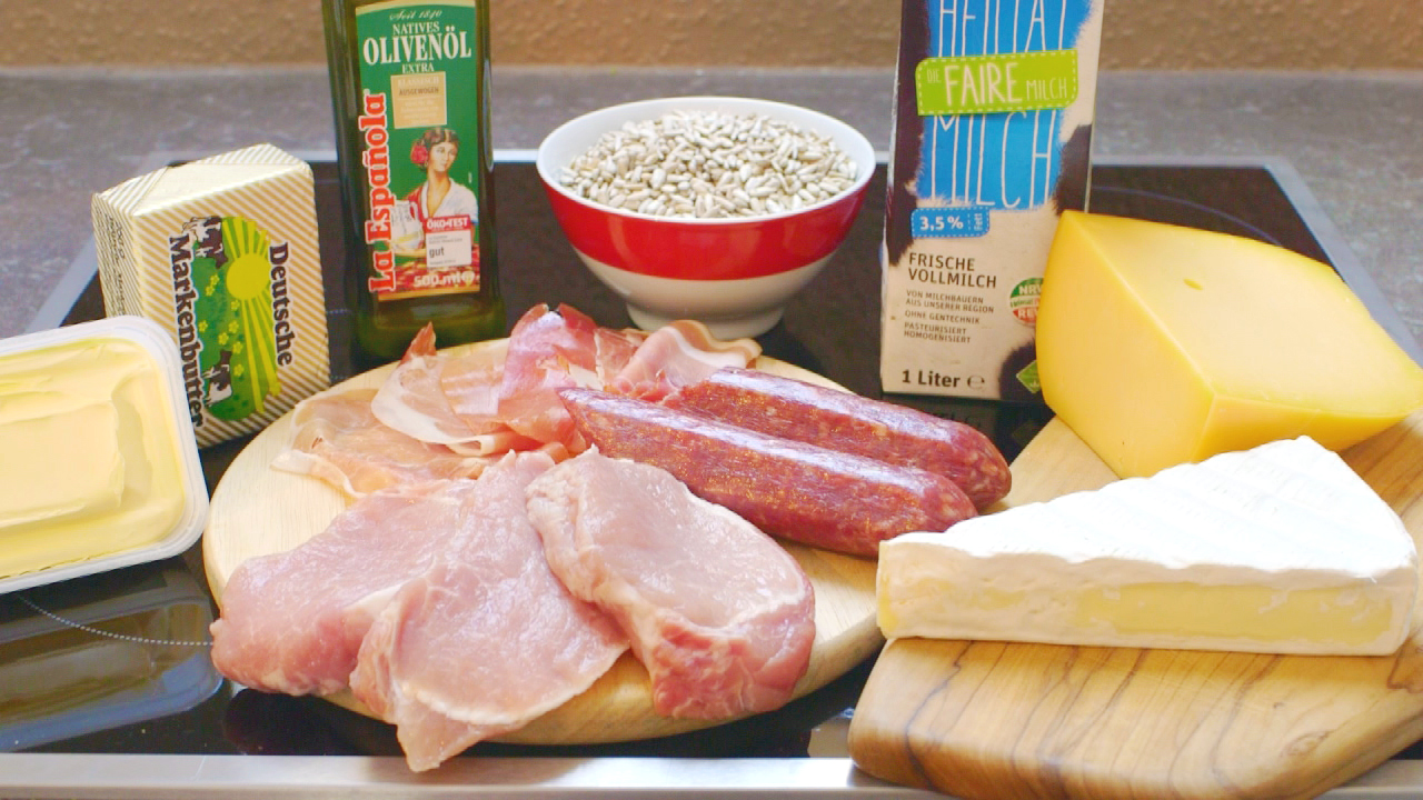 Zutaten für eine Mahlzeit: Olivenöl, verschiedene Fleischsorten, Käse, Butter, Sonnenblumenkerne und Milch.