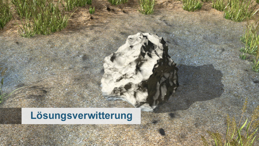 Ein großer, unregelmäßig geformter Stein auf einem sandigen Boden, umgeben von Gras.