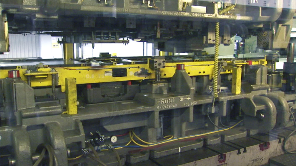 Industrielle Maschinenanlage mit gelben und grauen Komponenten, die für die Fertigung verwendet wird.