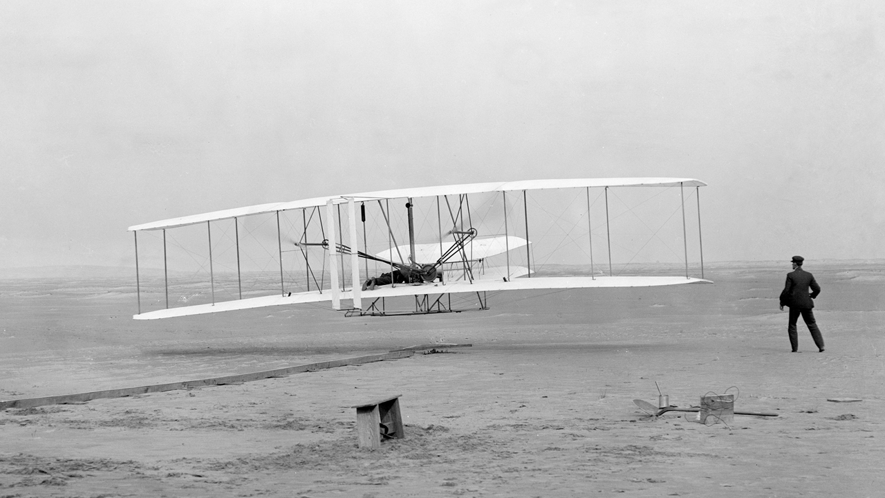 Der erste erfolgreiche Flug eines Flugzeugs, Wright Flyer, in Kitty Hawk, North Carolina, 1903.