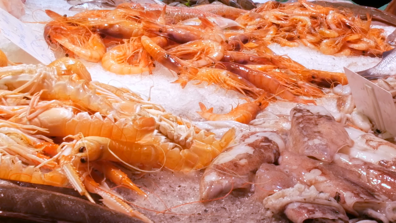 Frischer Meeresfrüchte-Markt mit verschiedenen Garnelen und Fisch auf Eis.