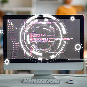 Fachbereich Informatik – Computerbildschirm mit Programmiercode und grafischer Benutzeroberfläche vor unscharfem Hintergrund