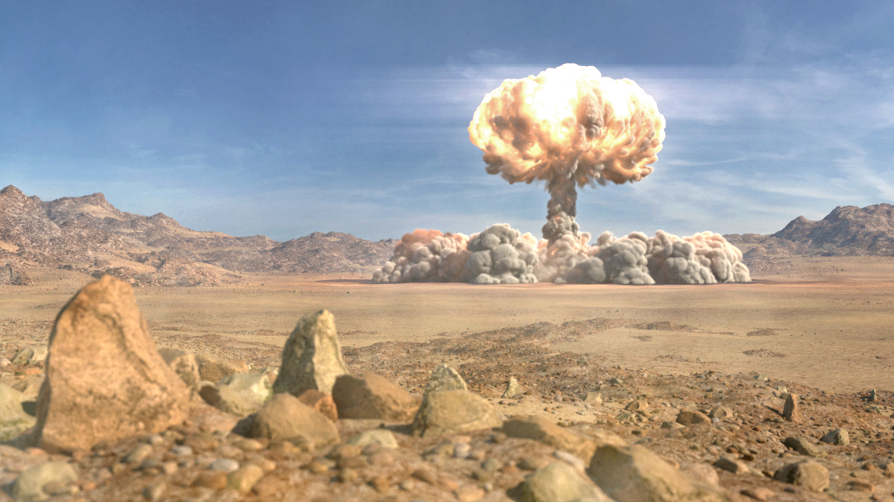 Eine Atombombenexplosion in einer Wüstenlandschaft, mit einer großen Pilzwolke und zerklüfteten Bergen im Hintergrund.
