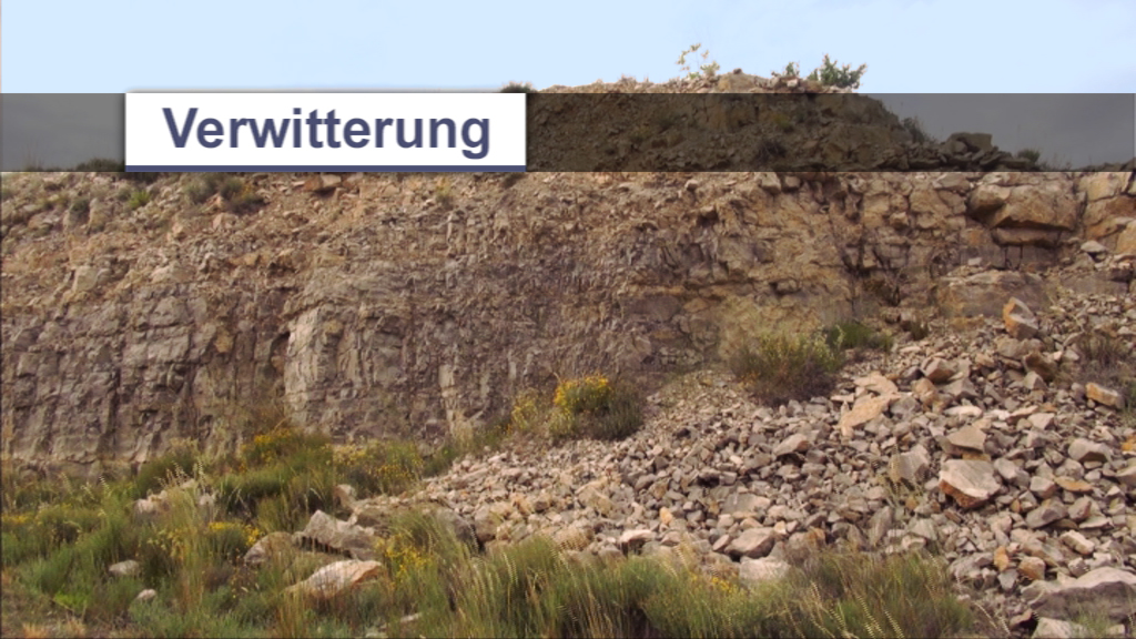 Felsformation mit sichtbaren Verwitterungserscheinungen und lockerem Gestein im Vordergrund.