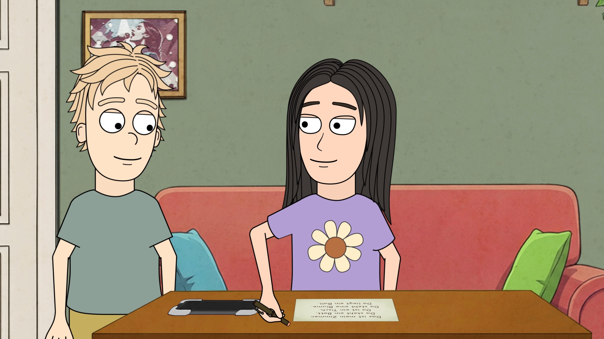 Zwei sitzende Personen vor einem Tisch mit einem Blatt Papier und einem Stift, im Hintergrund ein rotes Sofa mit bunten Kissen und ein Bild an der Wand