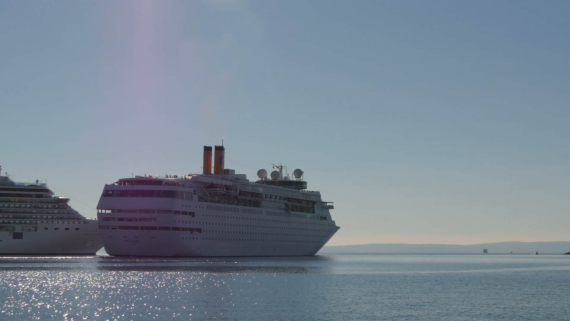 Ein Kreuzfahrtschiff fährt ruhig auf dem Wasser, umgeben von klarem Himmel und ruhiger See.